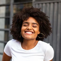 A young woman laughing with her eyes closed