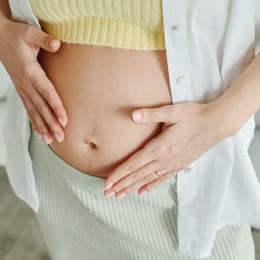 A pregnant woman with her hands on her belly